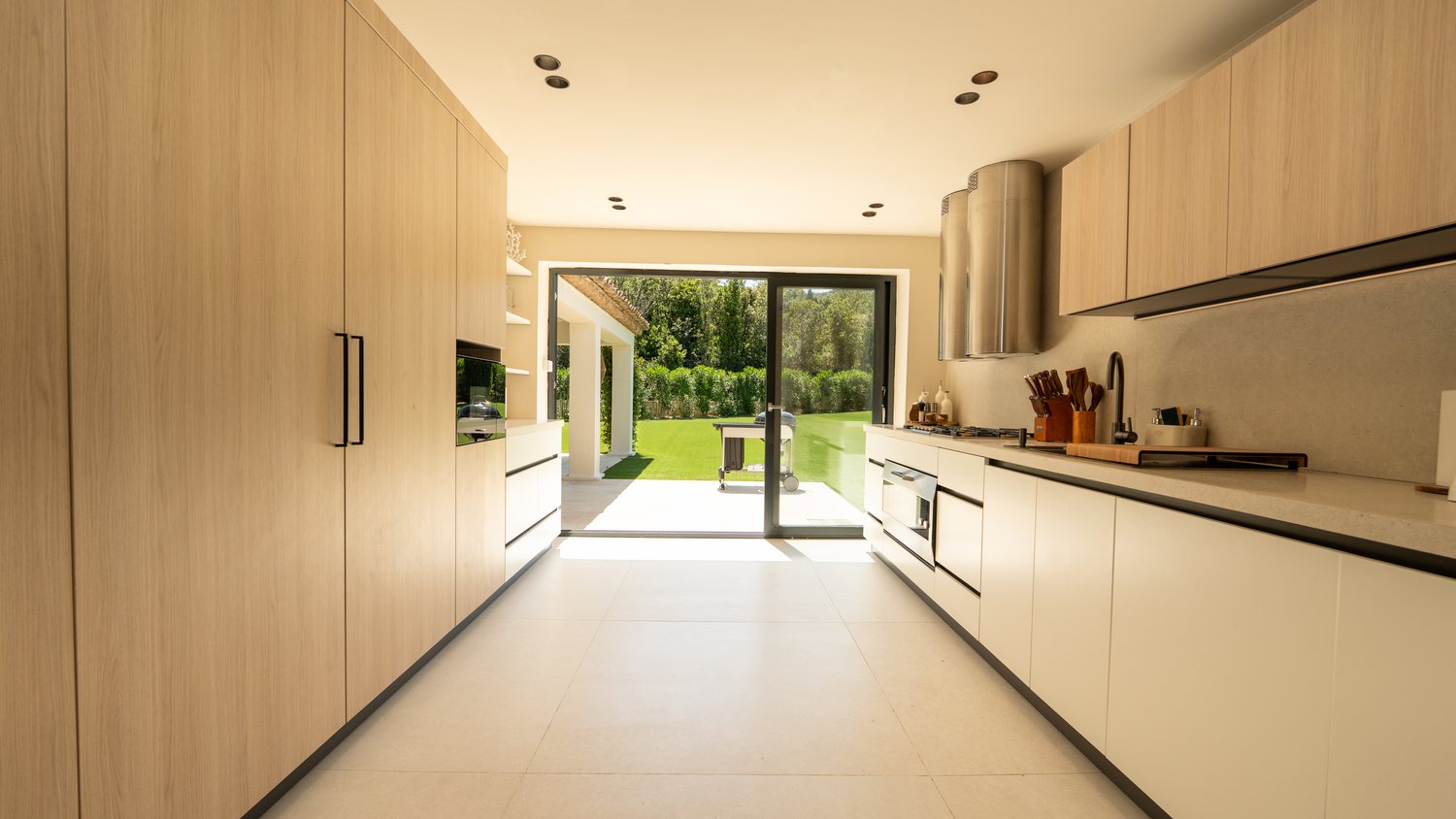 Villa Carpe Diem kitchen — Gaggenau Série 400, twin island hoods, Vicenza oak, natural stone